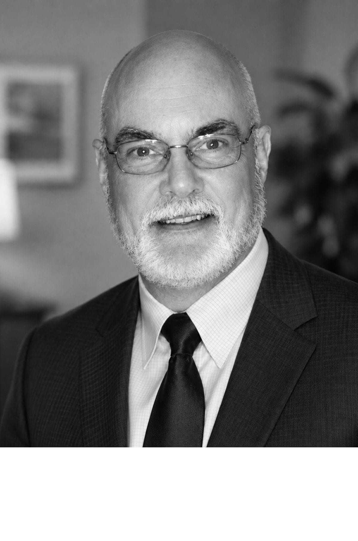 Portrait of Galen Kahlenberg in a dark jacket and tie, wearing glasses